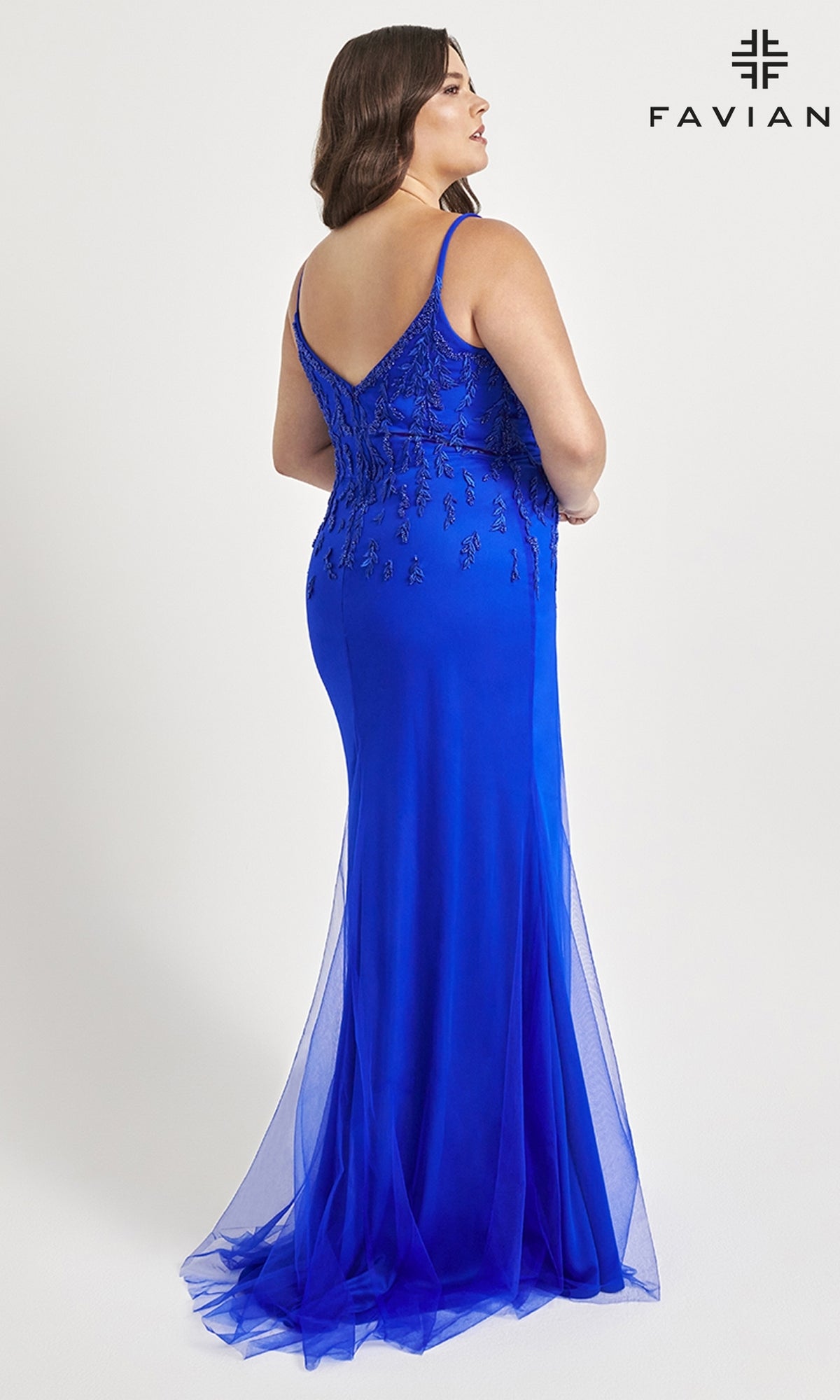 A woman models the Faviana Plus-Size Beaded Long Formal Dress 9559 in royal blue, featuring beaded embellishments on the back, as she stands facing away from the camera against a plain background with the Faviana logo in view.